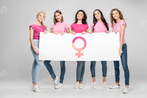 Preview: attractive young women holding large sign with female symbol on grey background