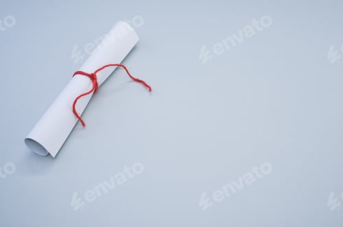 Preview: Closeup shot of a white paper scroll tied with red thread isolated on a gray background