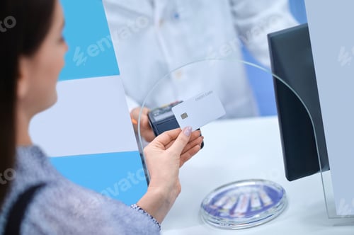 Preview: Dark-haired lady making a contactless payment at the drugstore