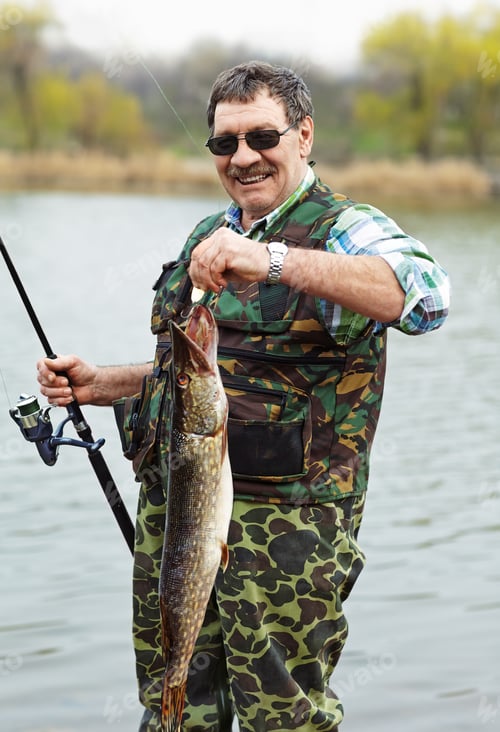 Adult man fishing on a river bank