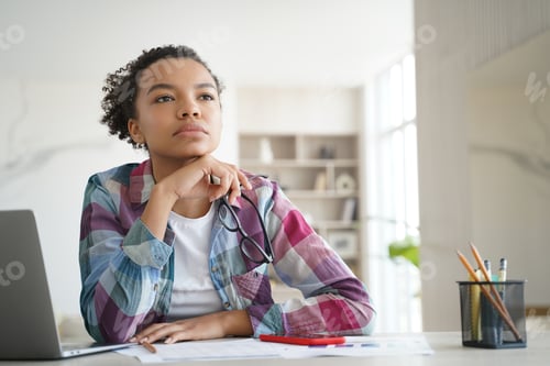 Preview: Teenage afro girl is bored at online lesson. Remote study at high school or college at home.