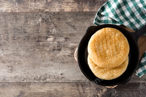 Preview: Delicious arepas resting in frying pan on rustic wooden table