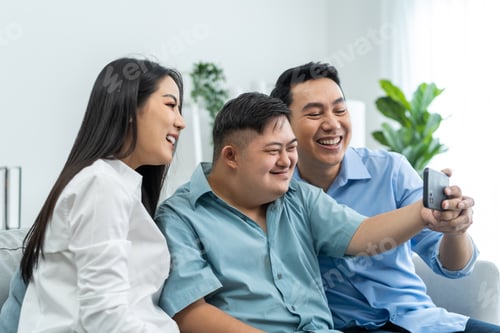 Preview: Asian attractive parents and young son using phone video call at home.