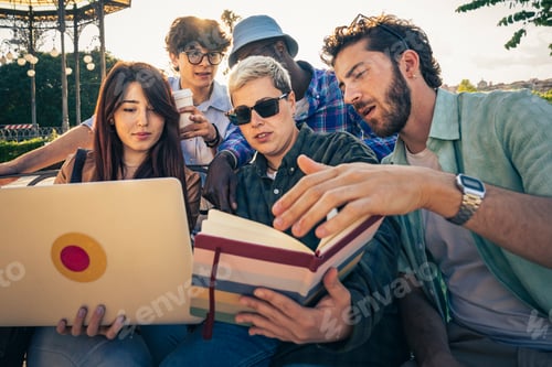 Preview: Group of friends collaborating on project using laptop and books outdoors