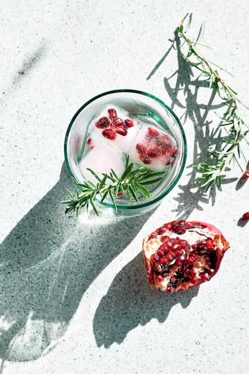 Preview: Pomegranate gin fizz cocktail with sparkling wine, rosemary and ice.