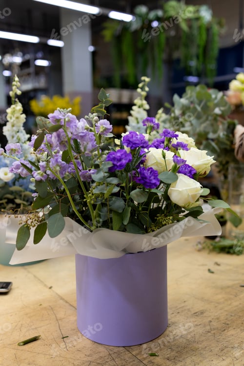 Preview: The composition of a bouquet of cream and purple roses and greenery