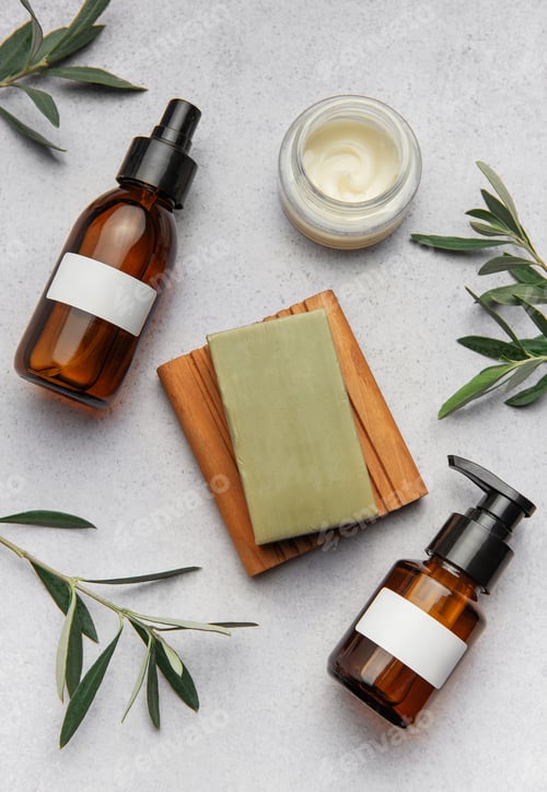 Preview: Natural cosmetics bottles, soap and cream surrounded by olive branches on marble background