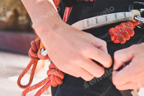 Preview: Male hands tying a knot for rock climbing.