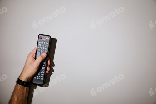 Preview: cropped view of man holding remote control in hand on white background