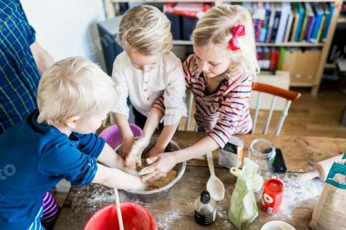 Preview: High angle view of children kneading dough at home