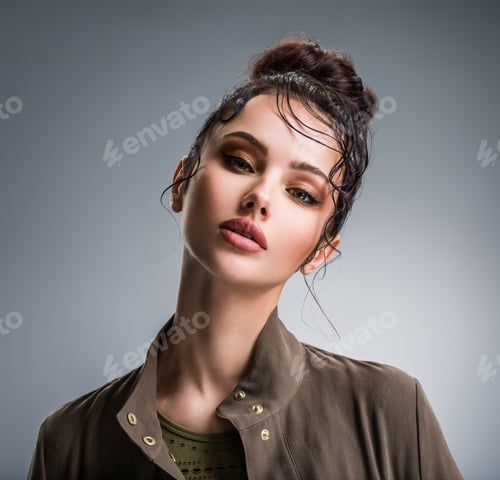 Preview: Closeup portrait of a beautiful young fashion woman with glamour makeup posing at studio.