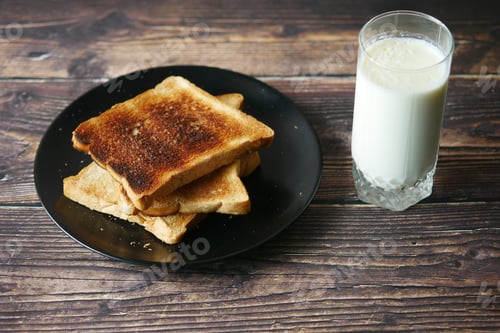 Preview: glass of whole cream milk and bread on table