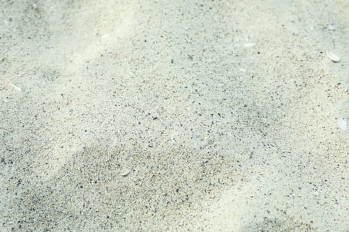 Preview: Sea sand as background, space for text, closeup. Summer backdrop