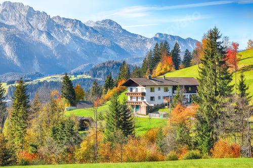 Preview: Alpine green fields and traditional wooden houses view of the Abtenau village at autumn sunny day.