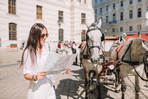 Preview: Young woman with a city map in city. Travel tourist girl with map in Vienna outdoors during holidays