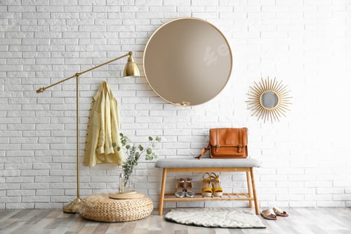 Preview: Hallway interior with big round mirror and shoe storage bench near brick wall