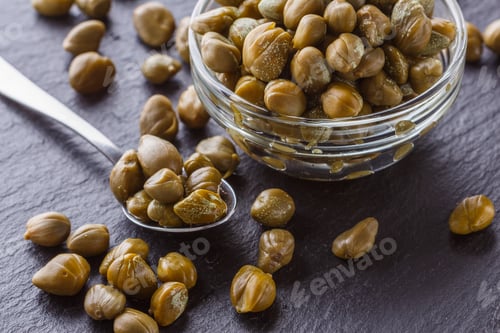 Preview: pickled capers on a dark stone background