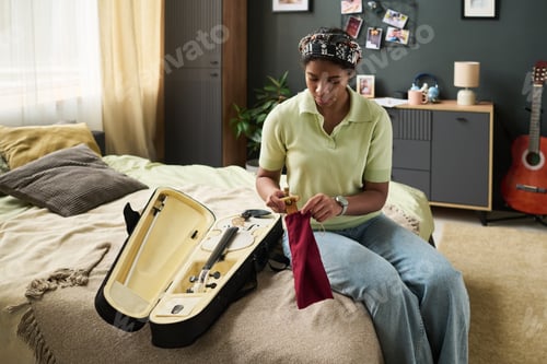 Preview: Girl Cleaning Violin in Cozy Bedroom Setting