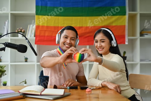 Preview: Male and female hands holding rainbow heart with smiling face.