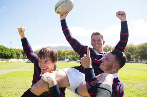 Preview: Portrait of happy rugby players enjoying at field