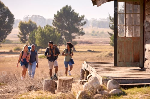 Preview: Group Of Friends With Backpacks Hiking In Countryside Together