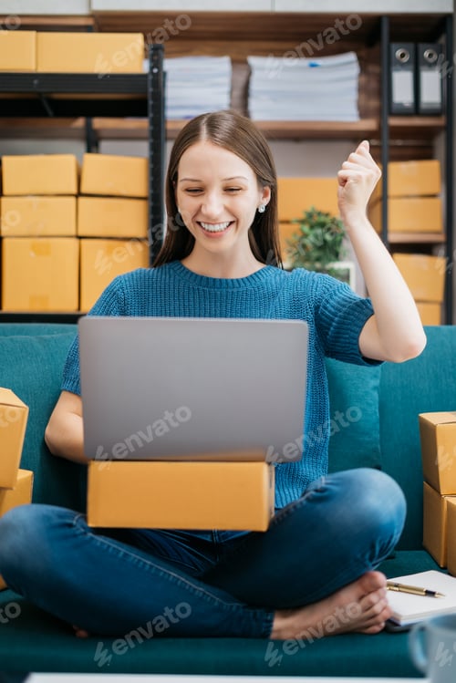 Preview: Happy businesswoman smiling at sales success after checking profits from home online store.