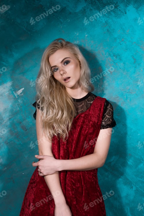 Preview: Beautiful Blonde Girl In A Red Dress Posing Against A Wall Green