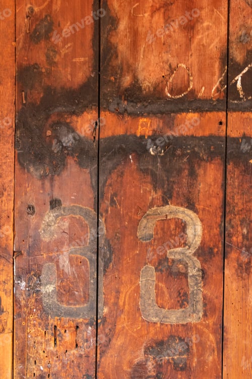 Preview: Vertical shot of numbers 33 on an old wooden door