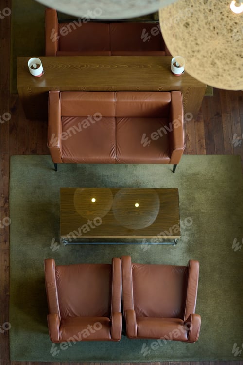 Preview: Above angle of brown leather sofa and two armchairs surrounding table
