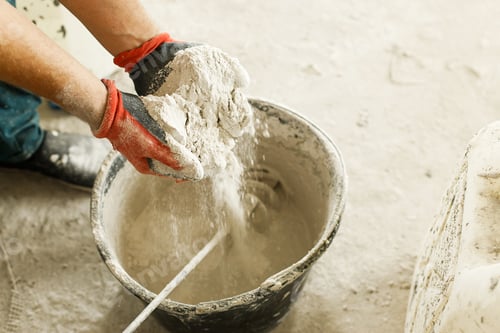 Preview: Worker mixing gypsum plaster with water for plastering walls