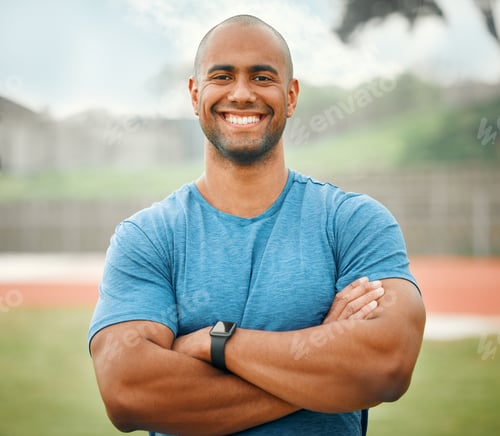 Preview: Cropped portrait of a handsome young male athlete standing outside with his arms folded