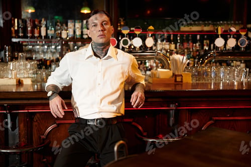 Preview: Nighttime allure of a tattooed man enjoying life at the bar with friends