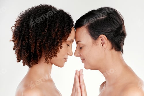 Preview: Cropped shot of two beautiful mature women posing against a grey background in studio