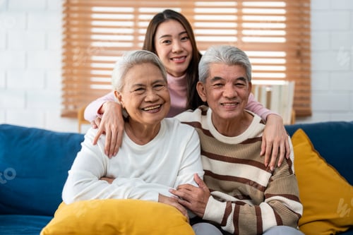 Preview: Portrait of Asian senior couple sitting on sofa with daughter in house.