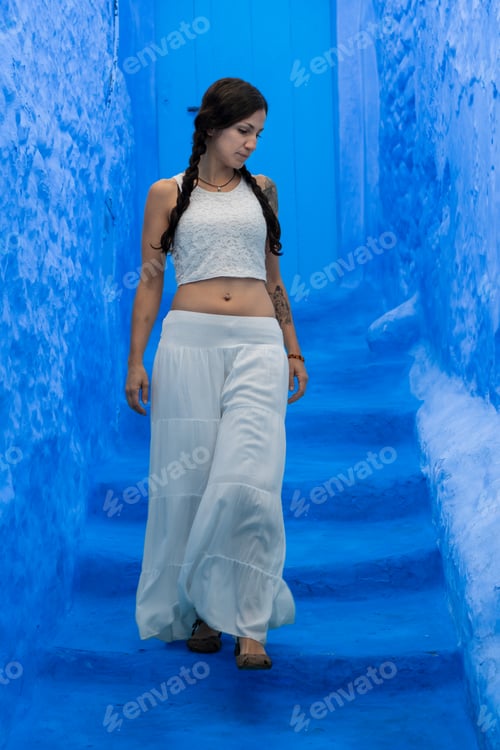 Preview: Young woman looking on blue wall