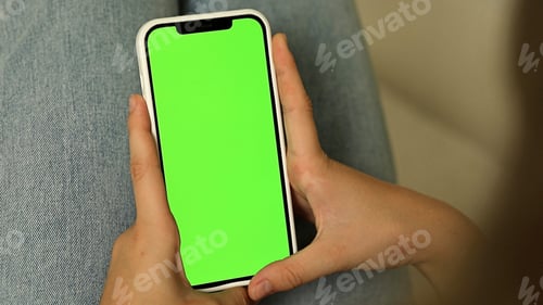 Preview: Green screen smartphone. Woman using mobile phone blank green screen vertical view for your