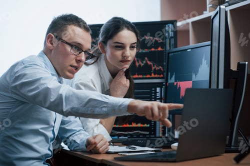 Preview: Team of stockbrokers are having a conversation in a office with multiple display screens