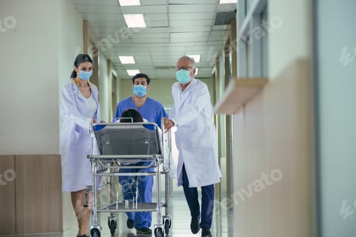 Preview: Paramedics carrying patient on gurney pushing and running towards the operating room