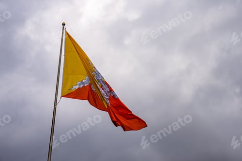 Preview: Bhutan national flag waving against a cloudy sky.