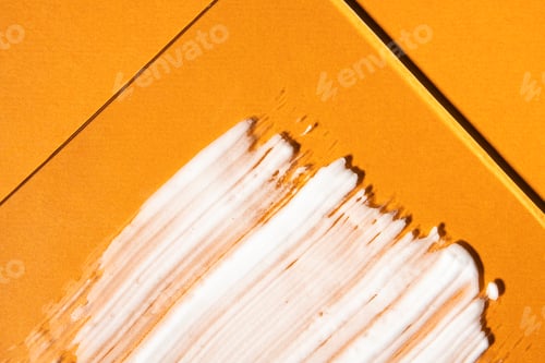 Preview: White colored sunscreen on a bright orange background, top view.