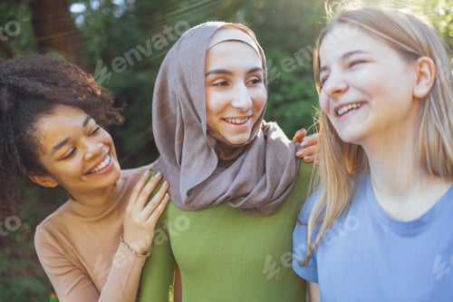 Preview: Multiracial young teen female friends walking in the park laughing
