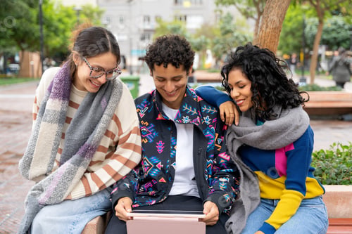 Preview: Young latin american friends sharing a digital tablet in the city