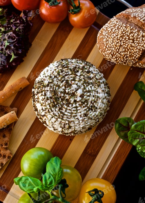 Preview: Flat lay of a healthy homemade cheese with herbs laying on the wooden board