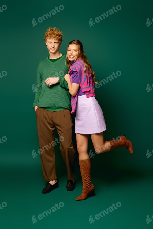 Preview: Vibrant couple showcases stylish romance in modern attire against a bold background