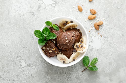 Preview: Chocolate and banana fruit ice cream with almond nuts served in bowls, top view