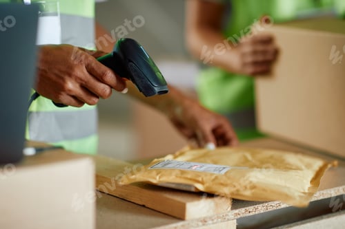 Preview: Close up of warehouse worker scanning labels on packages.