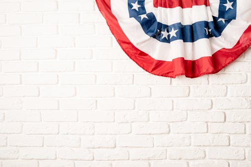 Preview: USA national flag on white brick wall background with copy space