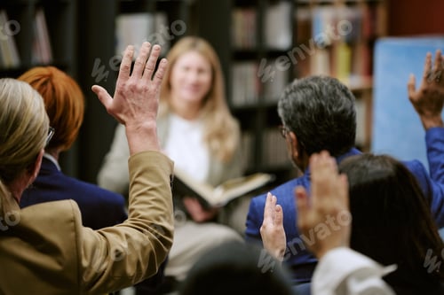 Preview: Diverse Group of Adults Raising Hands during Book Presentation in Library