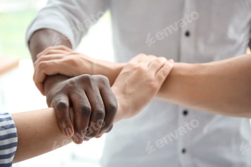 Preview: People holding hands on light background, closeup. Unity concept