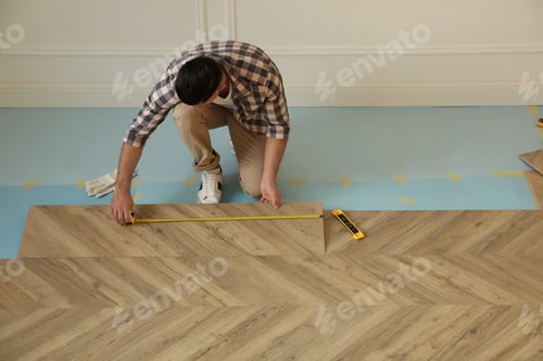 Ouvrier professionnel installant un nouveau parquet à l'intérieur, vue de dessus